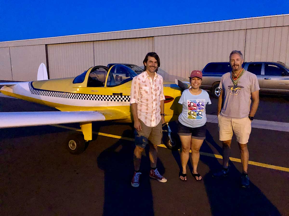 3 persons in front of a plane