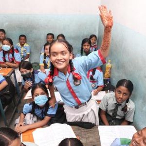 A young schoolgirl raise her hand