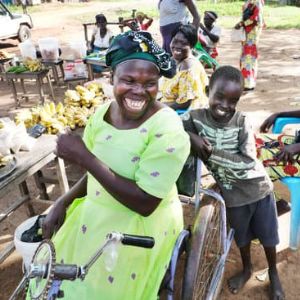 A woman with disabilities smilling among some children