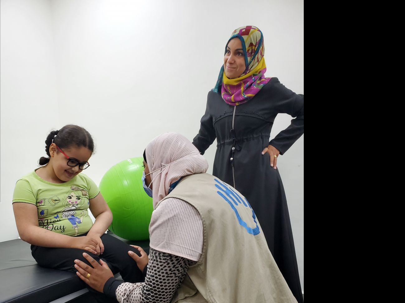 Judy (left) is joined by her mother Amani (right) in a rehabilitation session with HI.