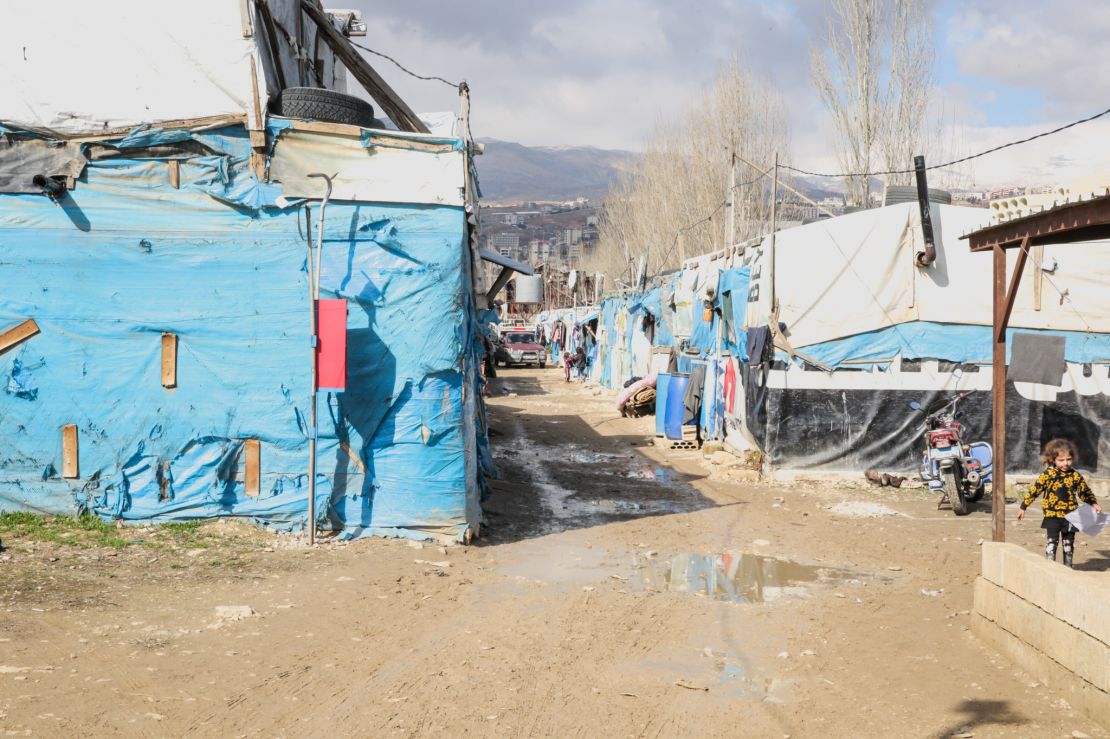 row of buildings made of tarp on a dirt road