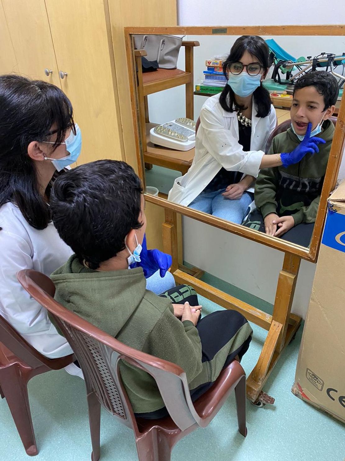 Ahmad is doing exercises with his occupational therapist.