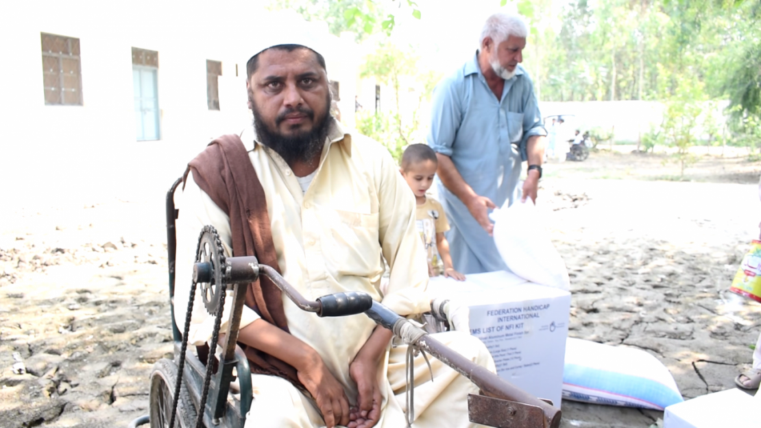 Man sitting in a wheelchair receives his emergency supply donation.