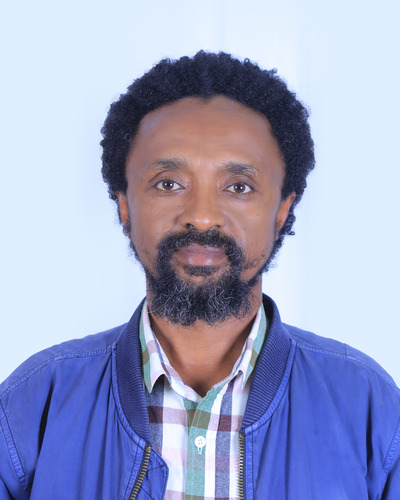 headshot of a man, Tilahun Abebe, HI's regional logistics manager. He looks directly into camera, on a white background.