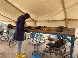 A technical aid worker fabricates and repairs mobility aids at a artificial limbs and braces workshop at the Kakuma Refugee Camp in Kenya. © E. Sellers / HI