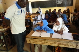 Malika, in blue head covering in class with Alio Assoumane, in charge of inclusive education at HI. © J. Labeur / HI