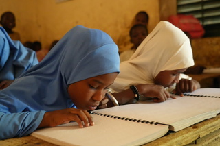 Malika, in blue head covering and her best friend Habsatou, in white head covering at their lessons, Maradi, Niger. © J. Labeur / HI