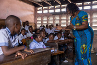 Daïsane and Mrs. Agnès during a lesson at Lemba inclusive school in the south of Kinshasa, surrounded by students inside a classroom