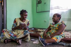 Daïsane playing cards with her sister Vasli at home