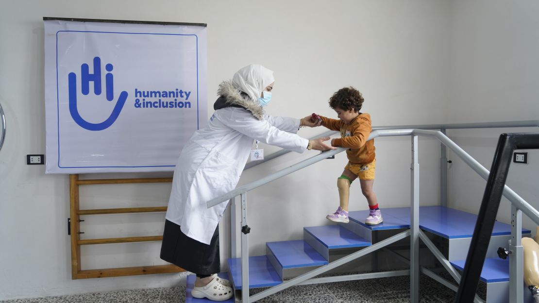 A young girl fitted with prostetics is making exercises with her physiotherapist 