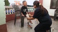 Prosthetist and Orthotist fitting a smiling young boy with a new prosthetic leg 