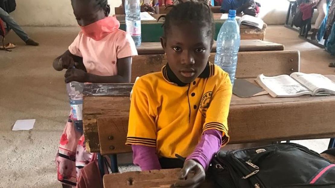 Aminata has returned to school and is studying hard in class.