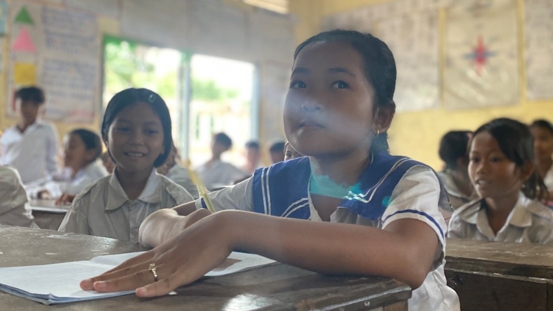 A girl sits at a school desk.