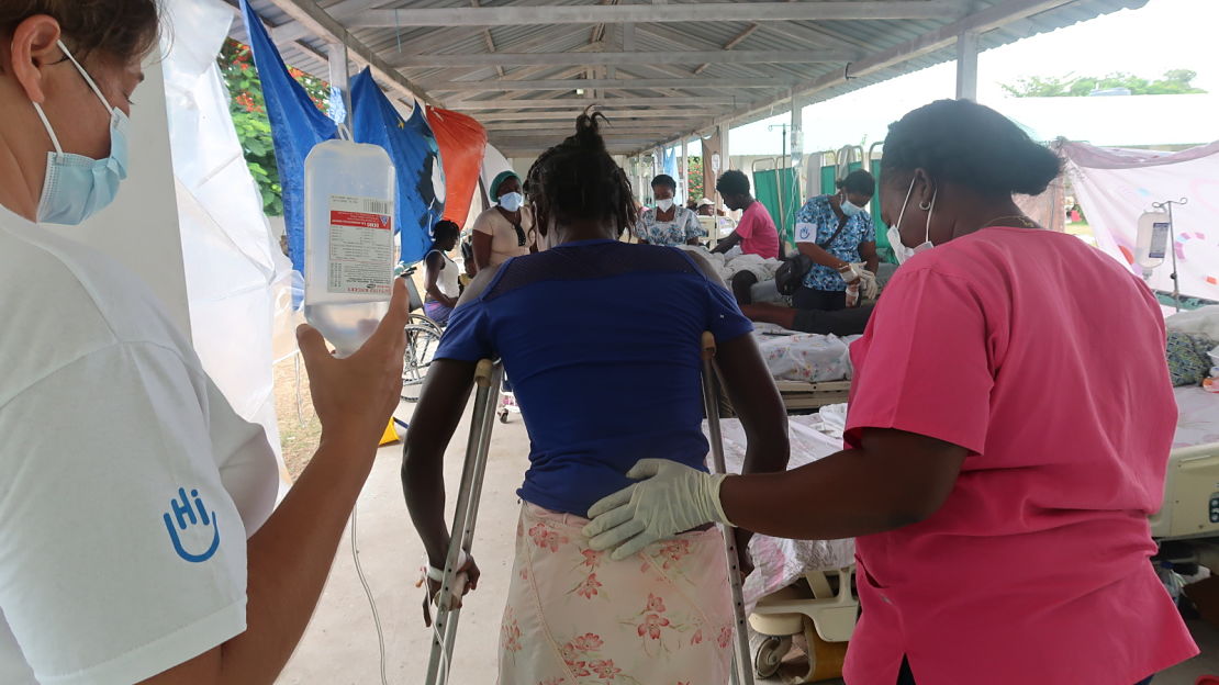 An HI rehabilitation specialist and partner physical therapist teach a woman to walk on her new crutches after breaking her tibia in the earthquake. Les Cayes, 2021