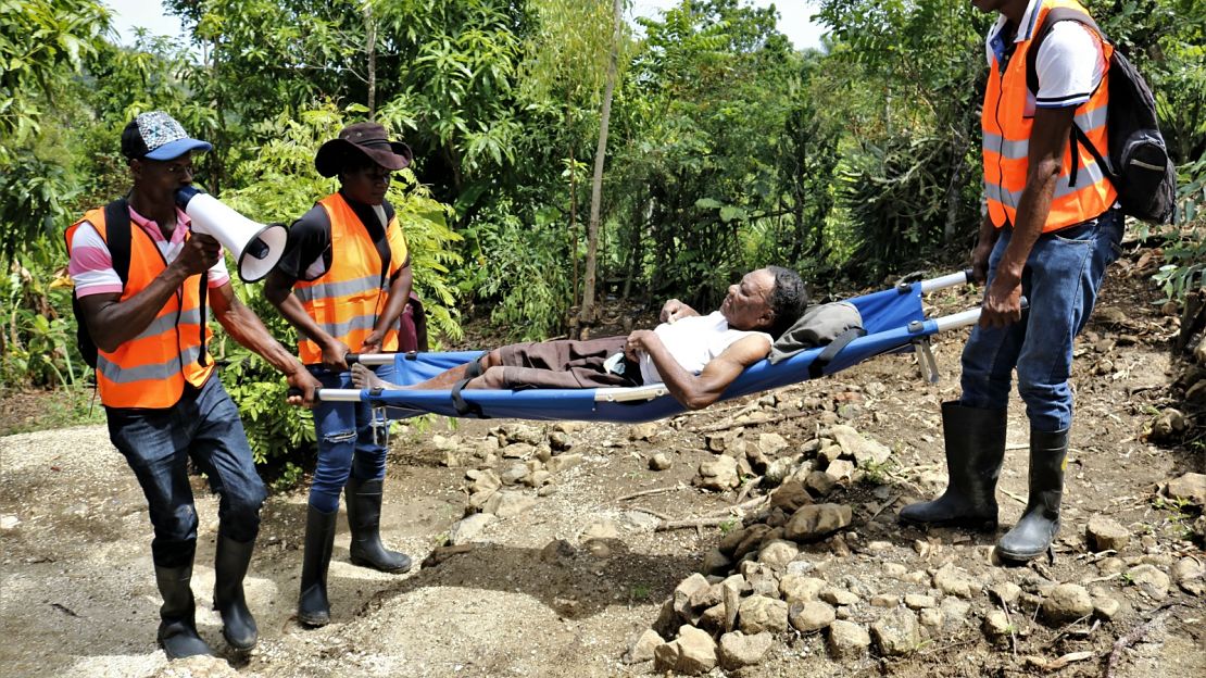 Volunteers carry a woman with a disability during an HI disaster simulation exercise, Haiti.