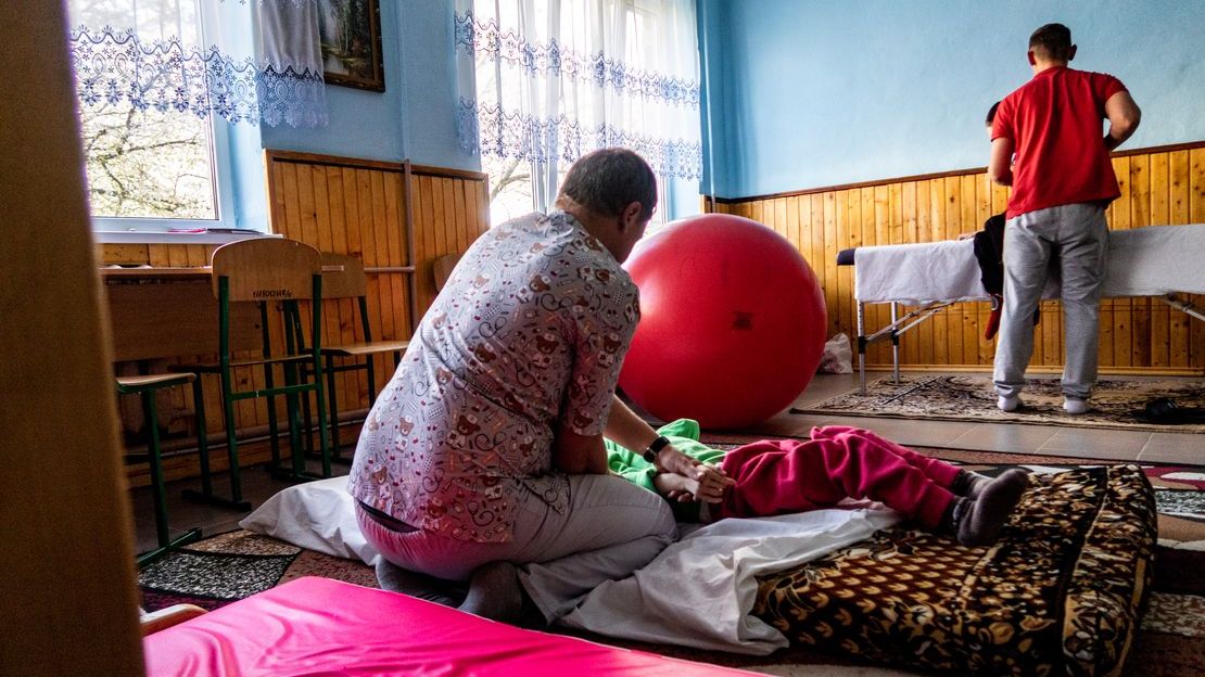 Carers doing rehabilitation exercises with children with multiple disabilities in a refuge in western Ukraine.