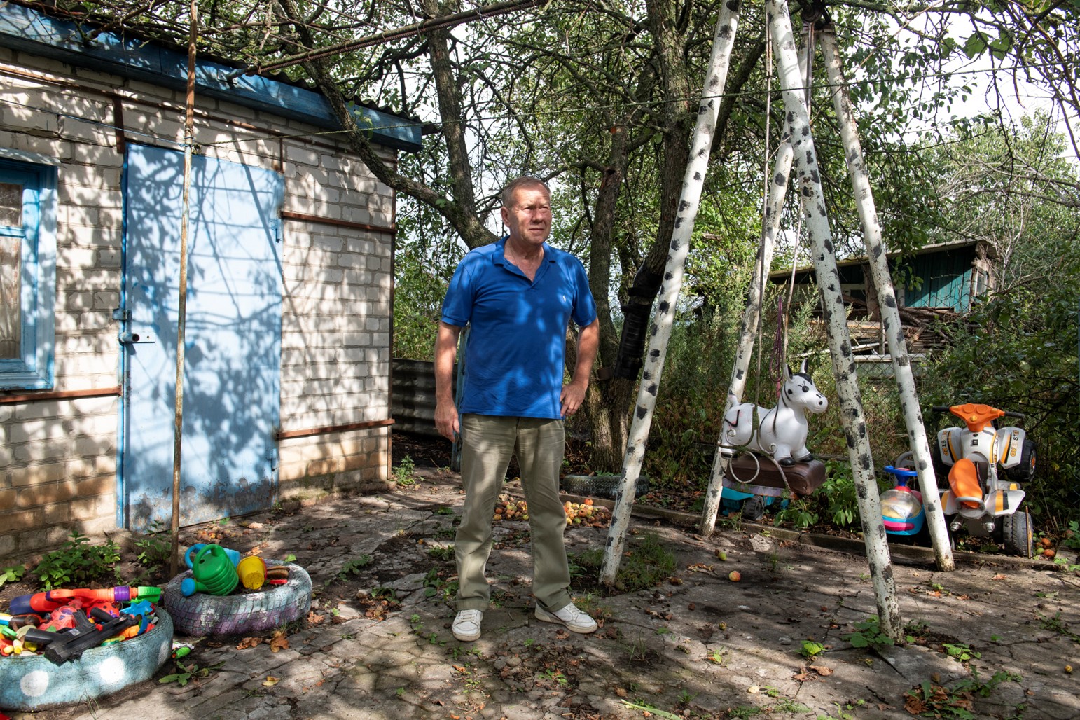 Mr. Volodymyr pictured in the yard of his home near the village of Zarazhne in Kharkiv Oblast. In February 2022 he was injured in a cluster munition strike on Kharkiv city and now has no feeling below his left thigh as a result of nerve damage. The strike, he says, was the first instance of cluster munitions in the war. When you are injured from cluster munitions he says, there is no end. He is a beneficiary of HI with cash assistance.