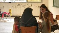 HI's psychologist talks to Amal in a school that's been converted into a reception center managed by the Union of Municipalities in the Tyre region.