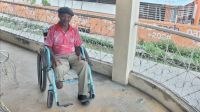 Man with amputation below the knee sitting in a wheelchair, smiling