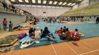 Families gather inside a gymnasium to seek shelter from the cyclone.