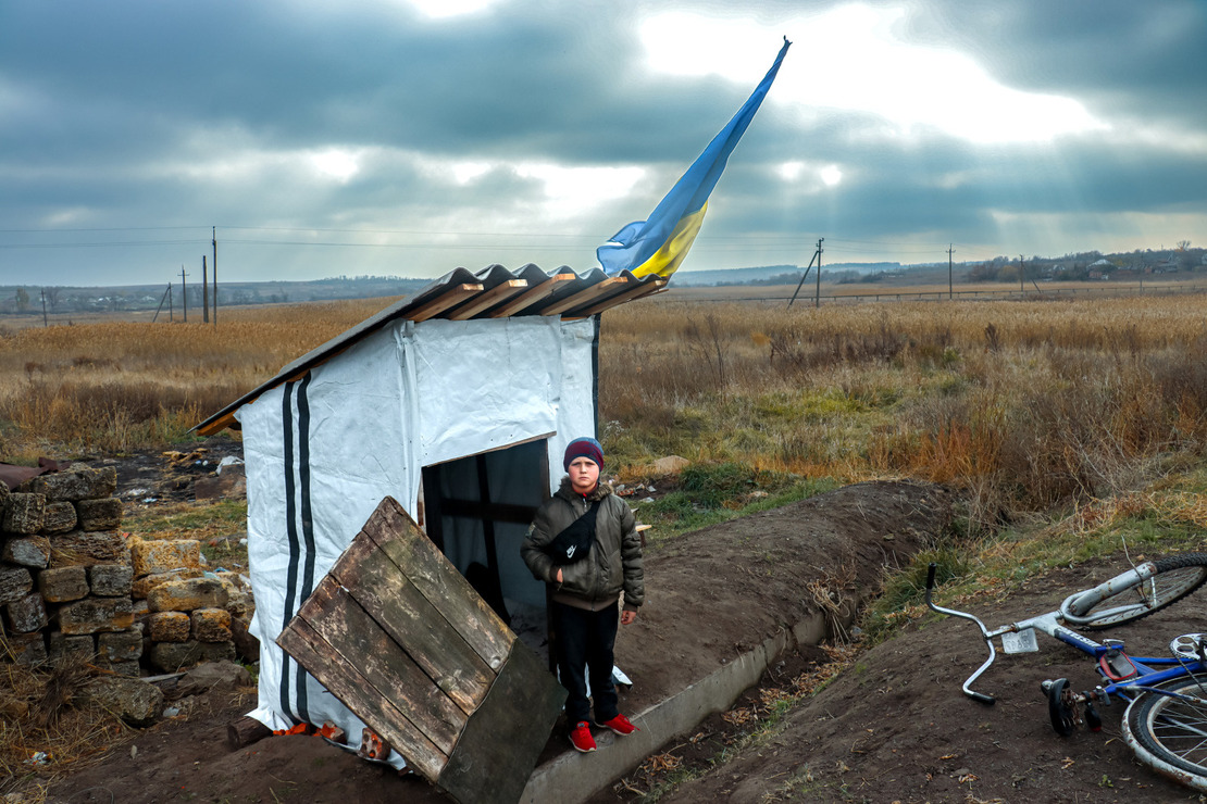 Nazar, 11, takes part in a risk education session in Velyka Komyshuvakha (Kharkiv region)A young boy in looking at the camera with the fields behind him