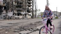 A young girl rides her bike next to houses destroyed by bombing in Borodyanka, Ukraine.