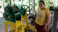 Portrait of Luz Abril standing beside her new mill.