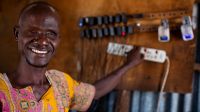 Ali charges phones in the shop he owns with his wife Abiba, in Kakuma Town, Kenya. Both Ali and Abiba are blind. They are from Kakuma and have received support for their shop from Humanity & Inclusion and other NGOs after NGO's arrived to support the influx of refugees. 