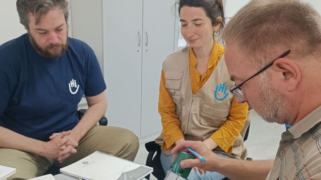 . HI staff, Jeremie (left) and Caglar (right) sign the official agreement to partner with the University of Medical Psychology of Chernivtsi and the Ukranian Psychosocial Organization. 