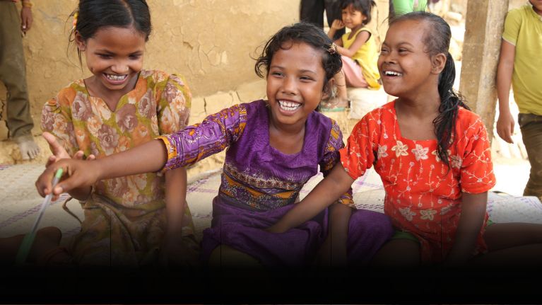 Three girls laugh together