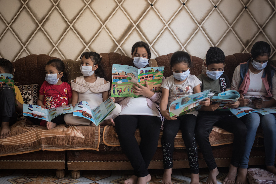 Children reading leaflets about the dangers of unexploded ordnance, Mosul, Iraq
