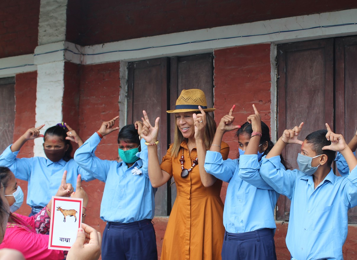 Girls with hearing disability teach Helen Grant member of Congress how to sign the word ‘goat’ in Nepali Sign Language.