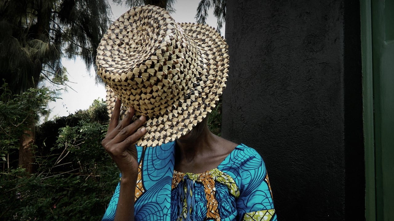 A woman with her face hidden by a hat.