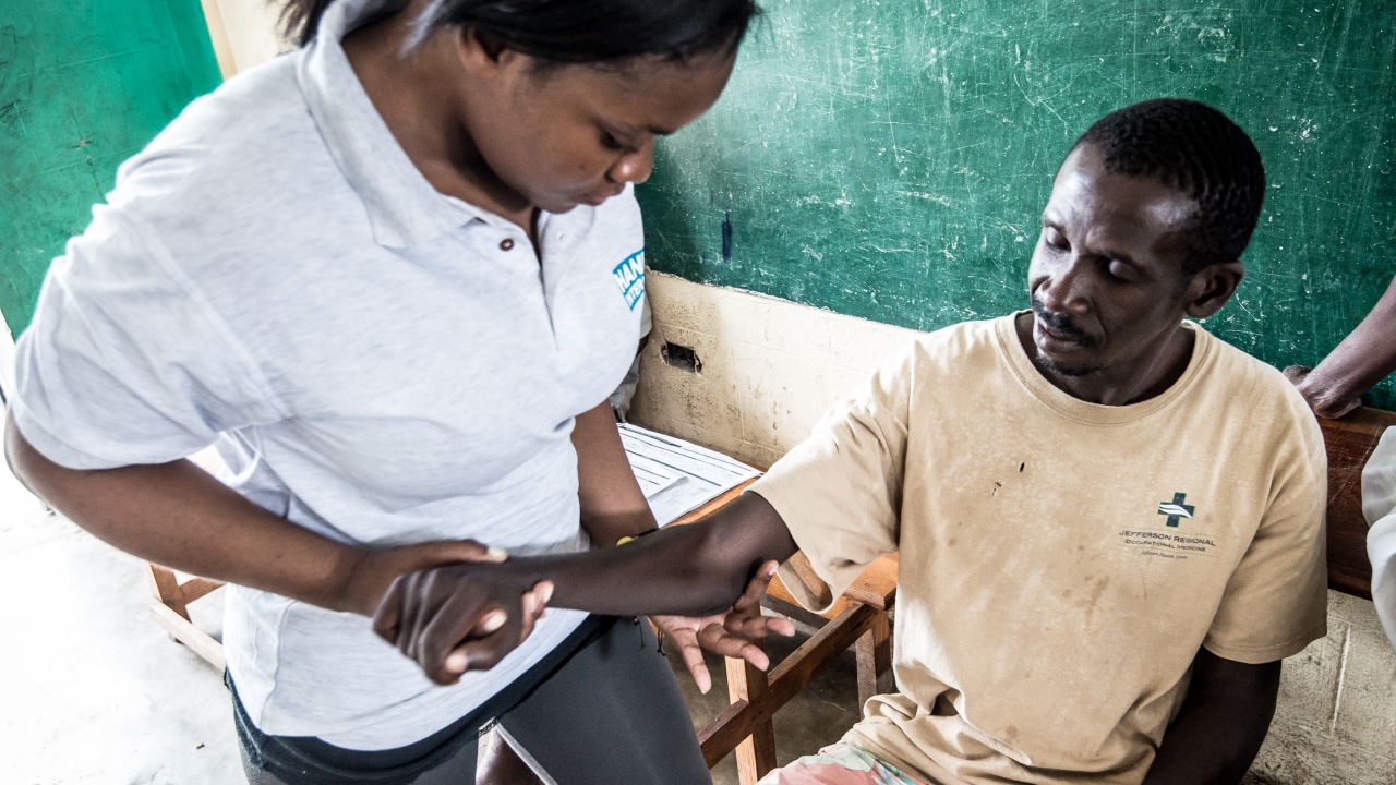 A man with hemiplegia receiving rehabilitation care from a Handicap International physical therapist, Haiti.