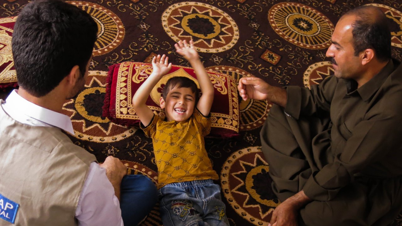 Razgar shows Hardi the exercises he does with his son every day.