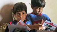 Two brothers look at the leaflets left by Handicap International’s team, at the end of a session.