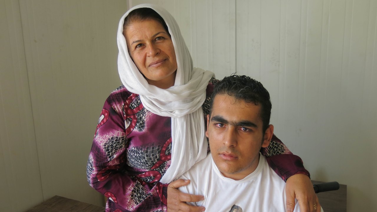 Badria and her son at a meeting organized as part of a capacity-building project for Syrians with disabilities and injuries. 