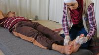 Ahmed has a rehabilitation session with a Handicap International physical therapist in Azraq camp, Jordan
