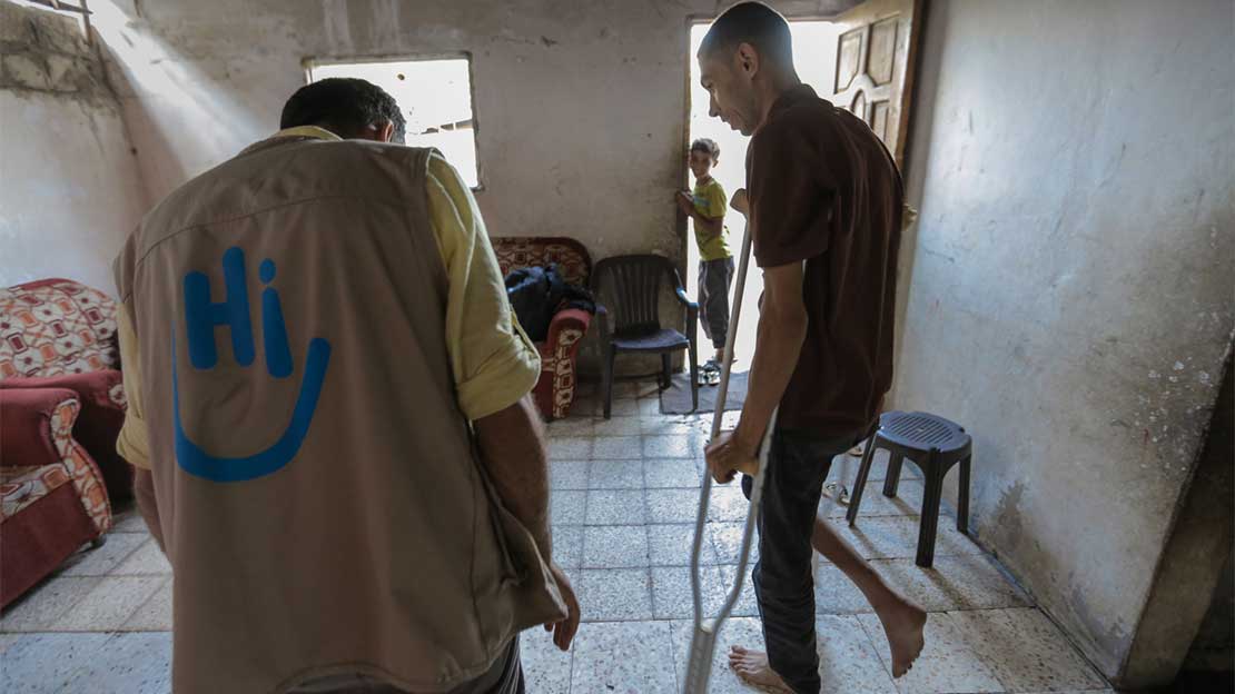 HI Staff assists injured civilian in rehabilitation session in Gaza, 2018