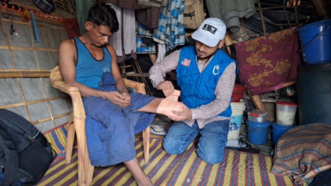 Abul Kalam receiving home-based rehabilitation services from HI's rehabilitation officer