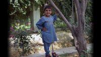 Sanaullah, 5, standing next to a tree wearing his artificial limb leg from HI. He lost his leg to a mortar in Afghanistan.