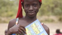Having just attended an awareness raising session, 11-year-old, Awo Goudiaby holds up a leaflet with drawings depicted important safety messages. Senegal.