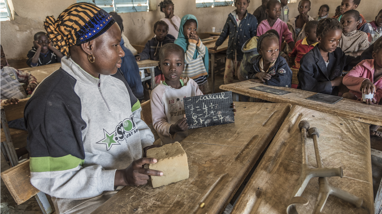 Samadou, 7, in class with a visiting Pedagogical Advisor, Burkina Faso