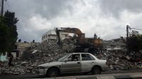 A car in front of building that have been destroyed and rubble that may contain explosive weapons. Gaza.