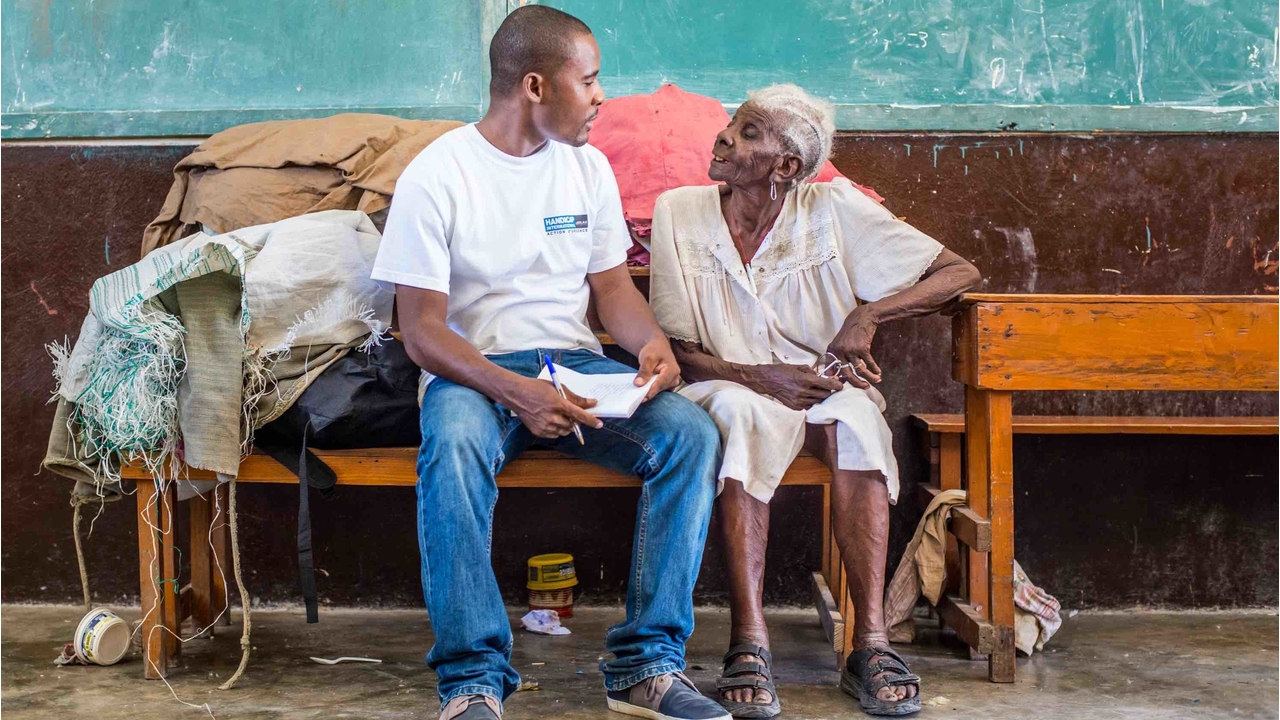 Handicap International's team with Méralia Simon, 90, who took refuge at Phillipe Guerrier secondary school, in les Cayes.