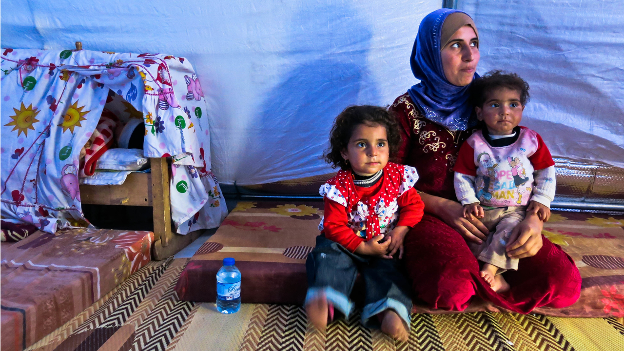 Hana and her three children in their tent.