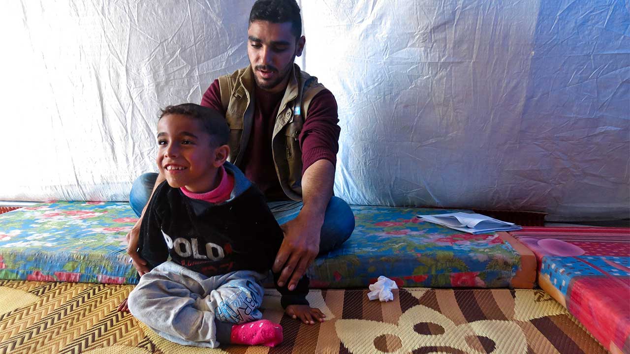 Zeidan does physical therapy exercises with Mohammed from Handicap International's team.