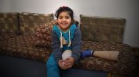 Salam sitting on the sofa with her artificial limb leg