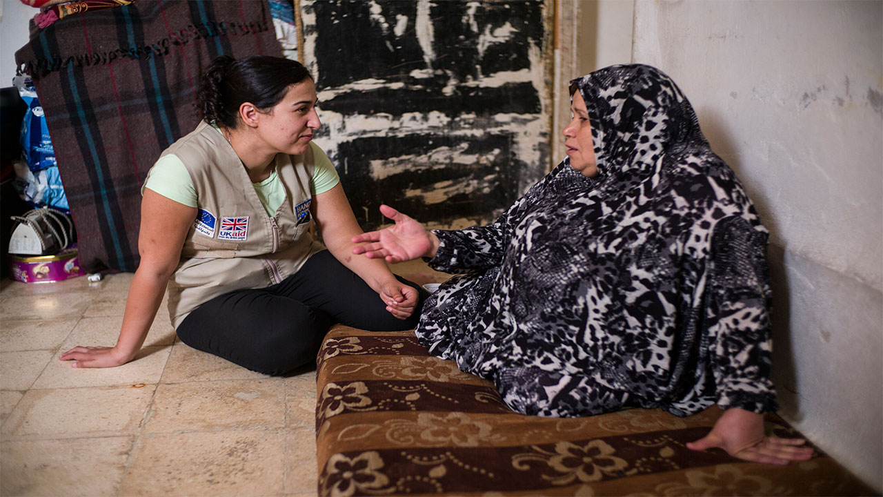 Ala'a with Aida, whose husband, Hassan, is receiving rehabilitation  care from Handicap International's team after several strokes left him partially paralyzed. Jordan.