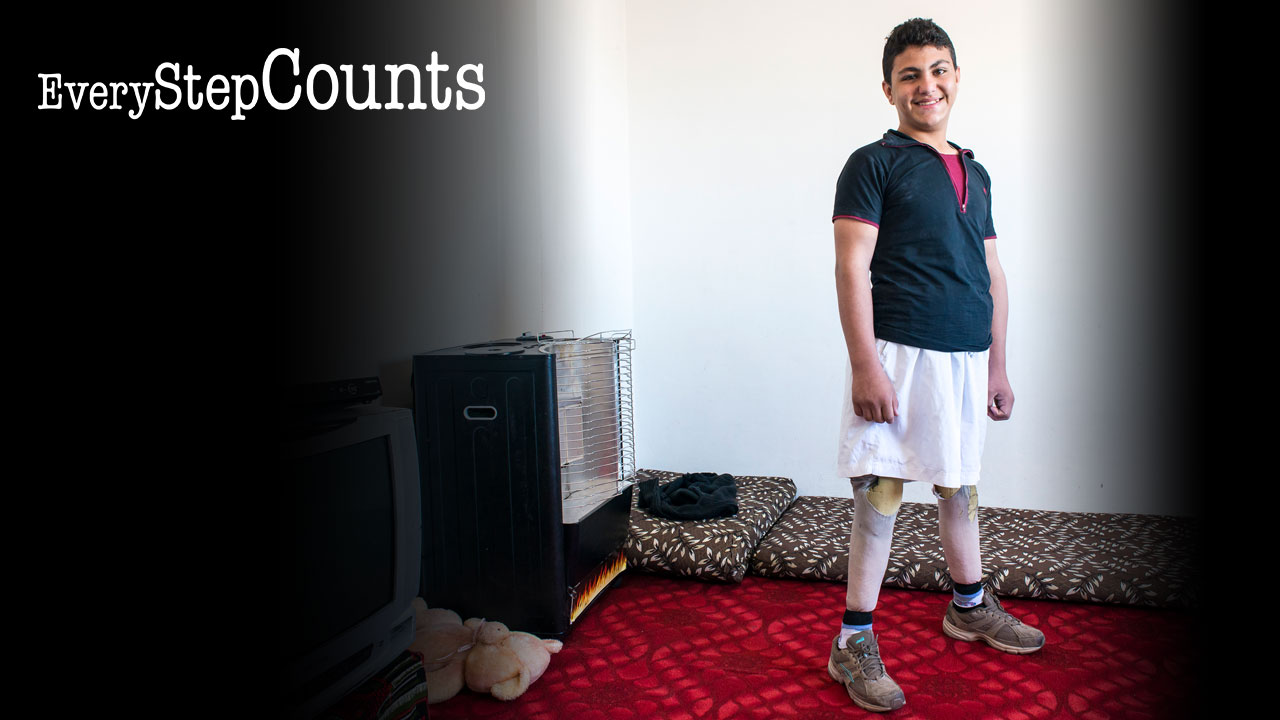 Qusay standing tall on his new artificial limb legs, Jordan